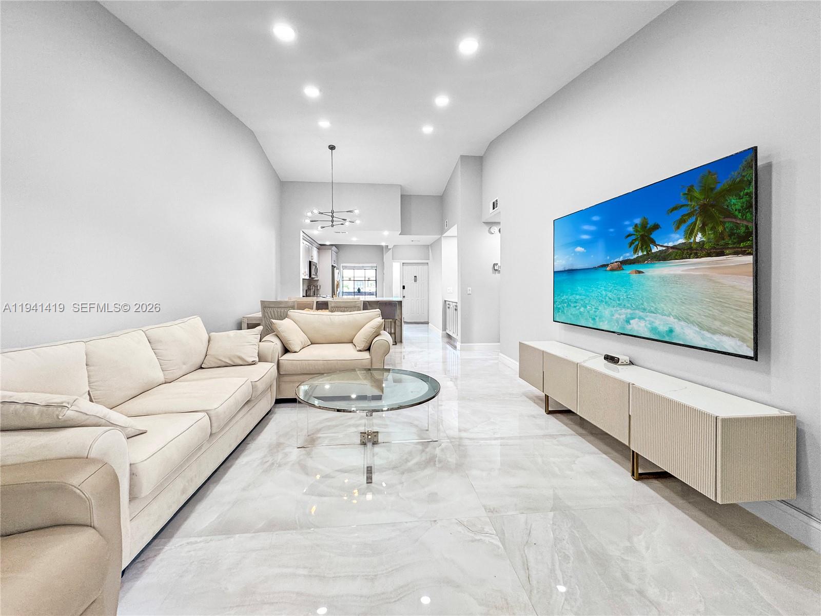 1977 Southwest 15th Street, Unit 116 Deerfield Beach, FL 33442 - Photo 6 of 37 a living room with furniture and a flat screen tv