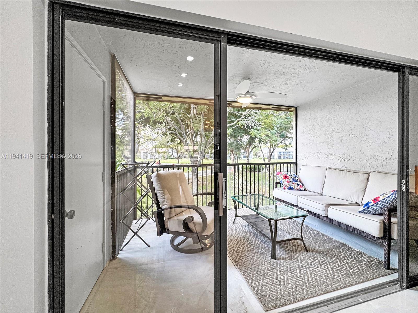 1977 Southwest 15th Street, Unit 116 Deerfield Beach, FL 33442 - Photo 7 of 37 a living room with a couch and a table