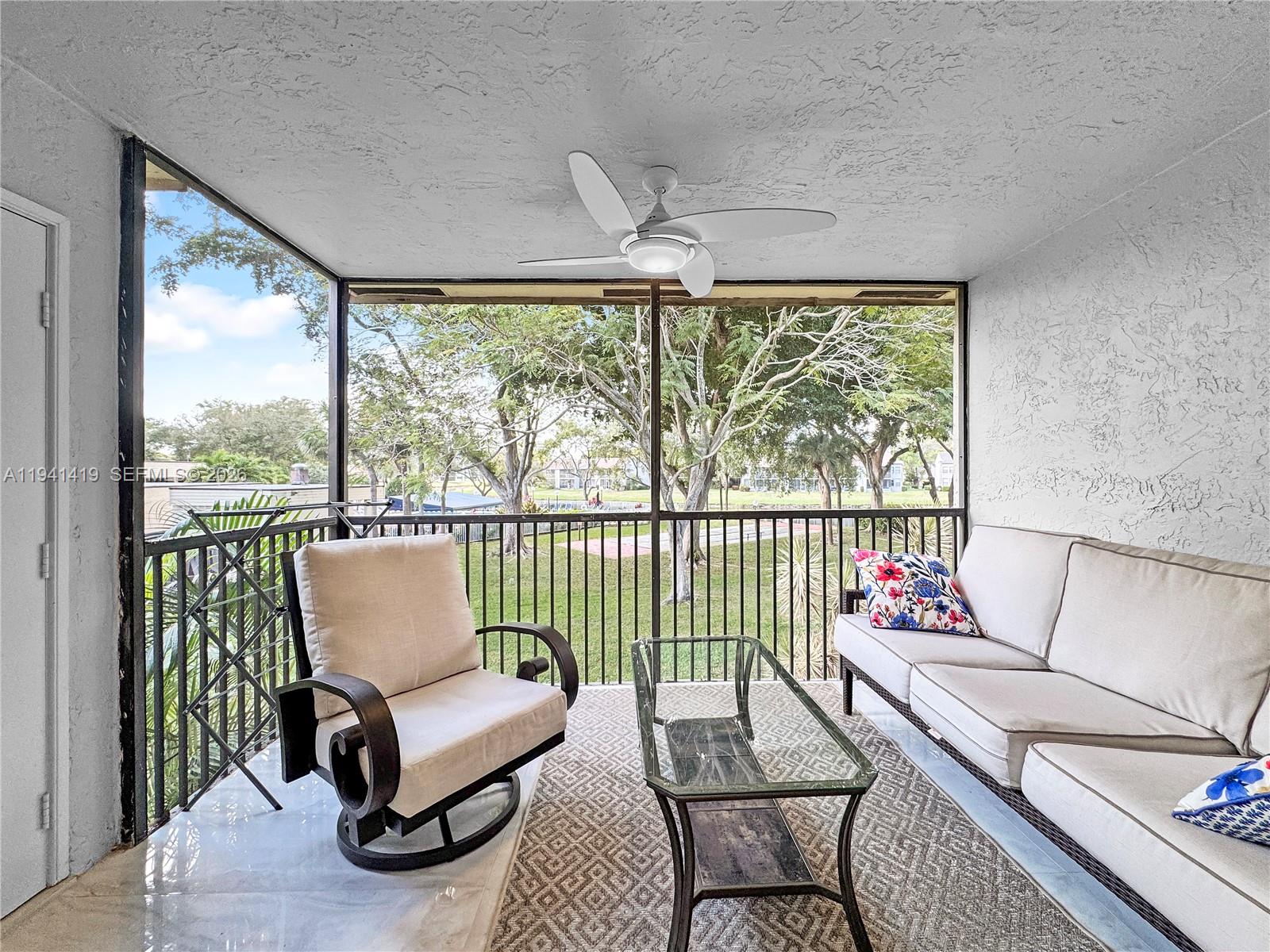 1977 Southwest 15th Street, Unit 116 Deerfield Beach, FL 33442 - Photo 8 of 37 a living room with furniture and a floor to ceiling window