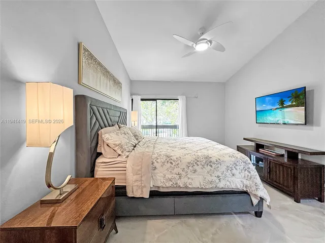 a bedroom with a bed a dresser and flat screen tv