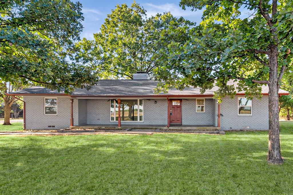 Light gray brick exterior with a dark shingle roof, a prominent red front door, and a covered porch entry