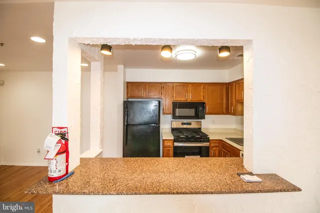 a kitchen with a refrigerator and a stove top oven
