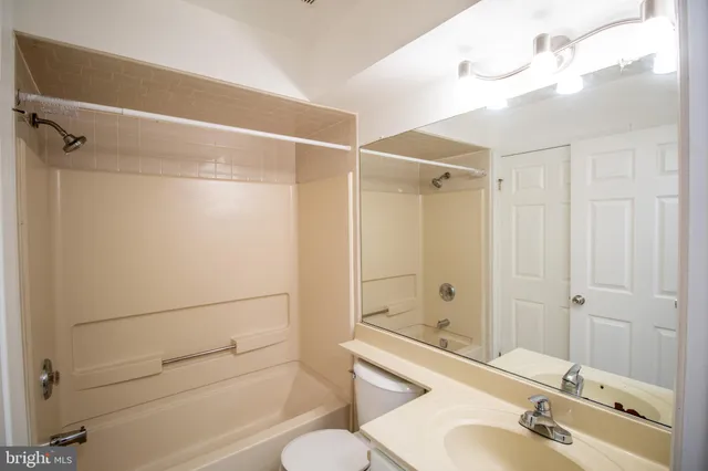 a bathroom with a shower sink vanity and toilet