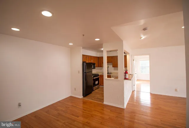 a view of a big room with wooden floor windows and a kitchen view