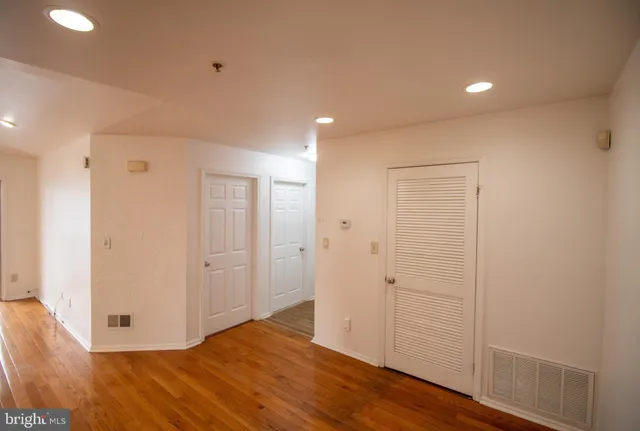 a view of an empty room with wooden floor