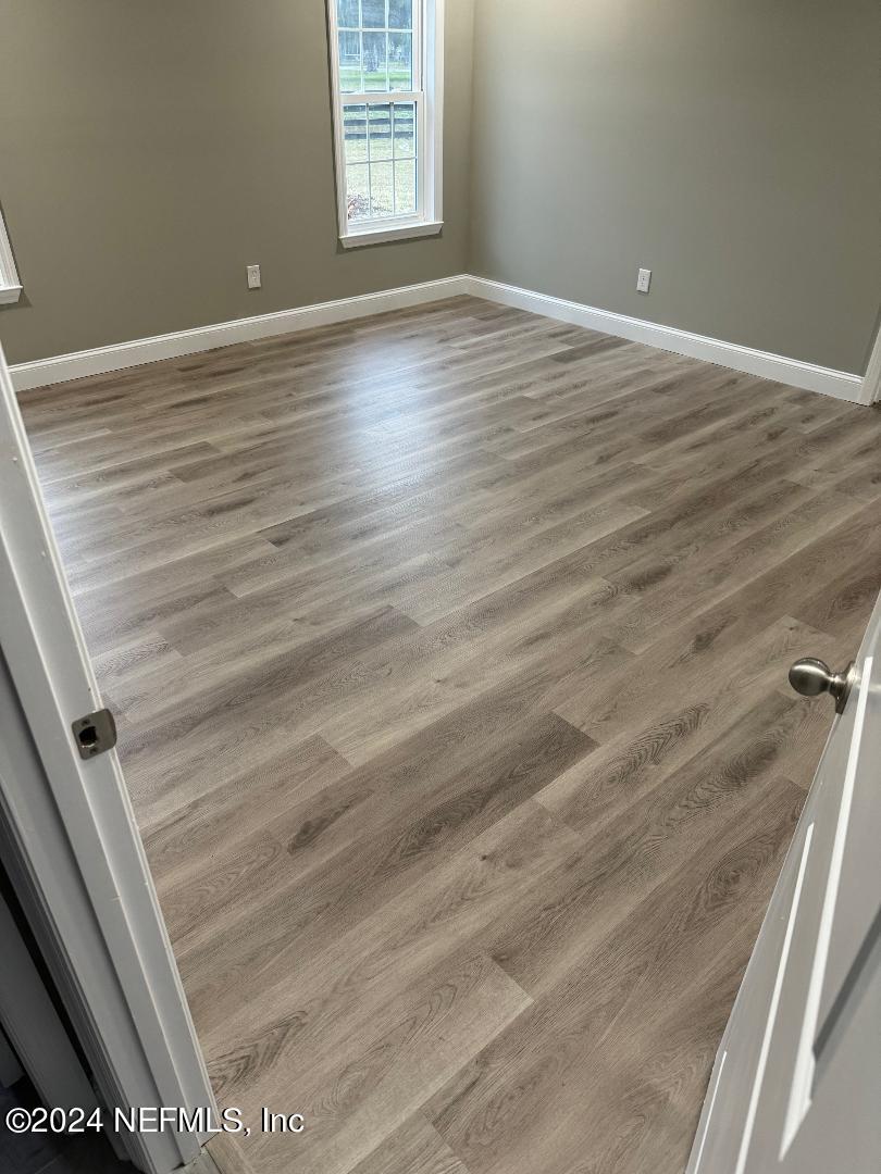 868 Jones Road Jacksonville, FL 32220 - Photo 19 of 19 a view of an empty room with wooden floor and a window