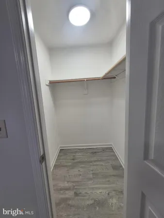 a view of walk in closet with empty racks