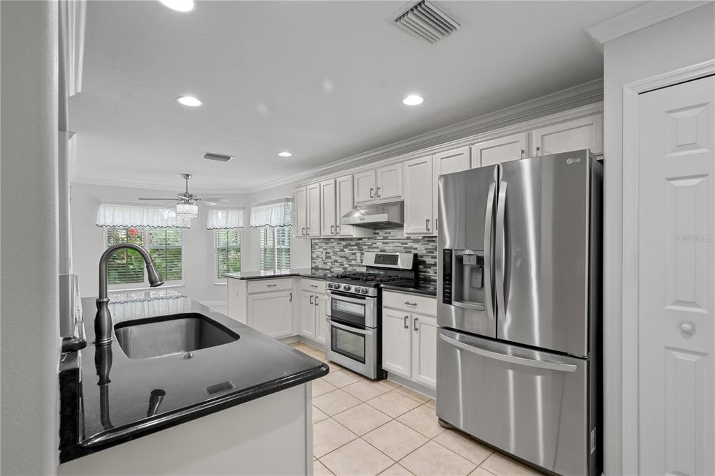 15692 Southwest 11th Court Road Ocala, FL 34473 - Photo 25 of 49 a kitchen with kitchen island stainless steel appliances a refrigerator sink and stove