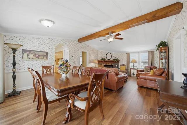 a living room with furniture kitchen view and a wooden floor