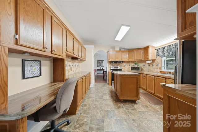 a kitchen with stainless steel appliances granite countertop a refrigerator a stove top oven a sink and dishwasher