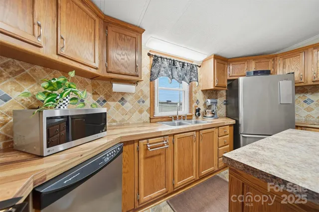 a kitchen with stainless steel appliances a stove microwave and refrigerator