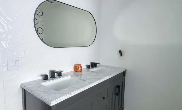 a bathroom with a granite countertop sink and a mirror