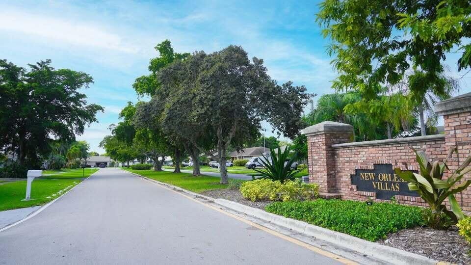 7410 Southwest 15th Street Plantation, FL 33317 - Photo 3 of 14 a front view of a house with a yard and trees