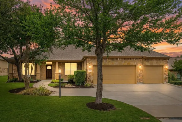 a front view of a house with a yard and palm trees