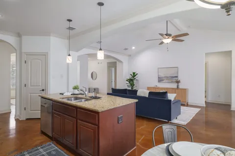 a bathroom with a granite countertop sink a toilet a mirror and shower
