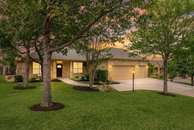 a view of a house with backyard and a tree