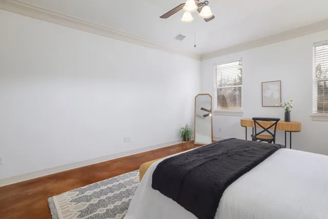 a bedroom with a bed a chandelier and dresser
