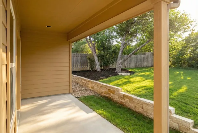 a view of backyard with large trees and plants