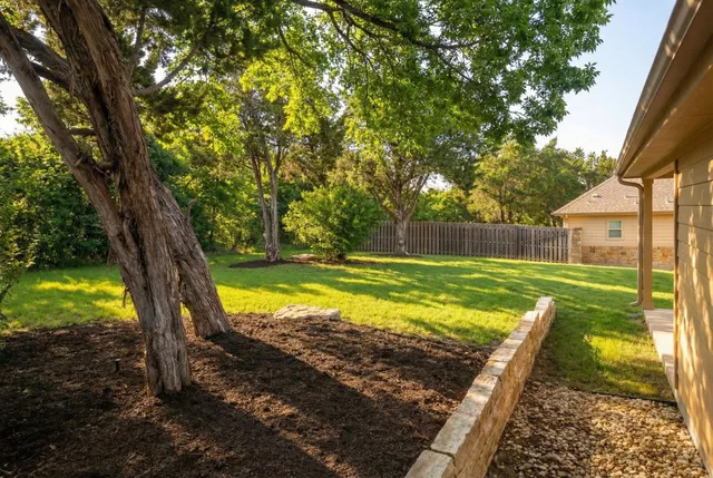 a view of a yard with large trees