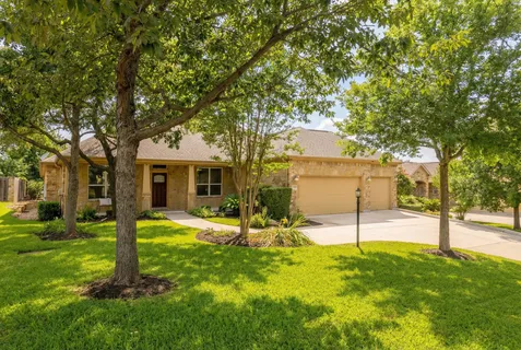 a view of a house with backyard and tree