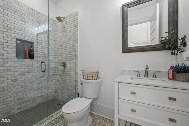 a bathroom with a granite countertop toilet sink and mirror