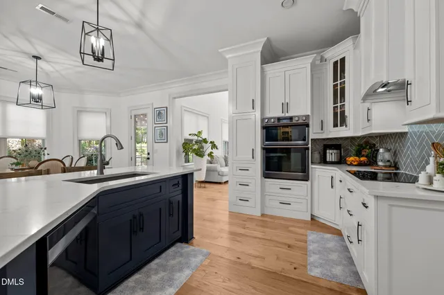 a kitchen with stainless steel appliances kitchen island granite countertop a stove top oven a sink dishwasher and a refrigerator with wooden floor