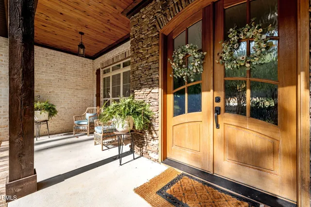 a view of a balcony with chairs and a potted plant