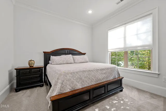 a bedroom with a bed dresser and a window