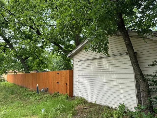 a backyard of a house with lots of plants and tree