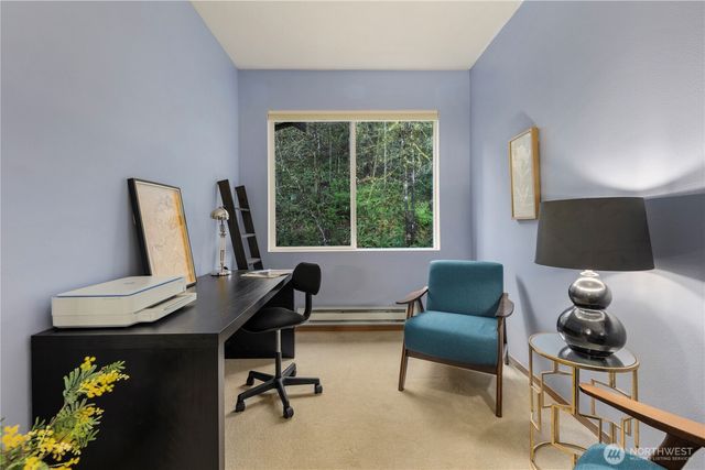 a view of a workspace with furniture and a window
