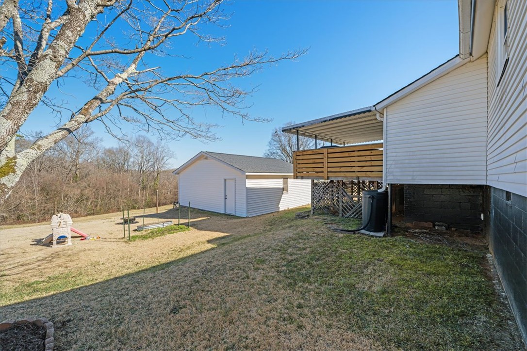6 Fuller Street Pelzer, SC 29669 - Photo 29 of 36 This spacious backyard offers ample outdoor living space with a shed and a private deck.