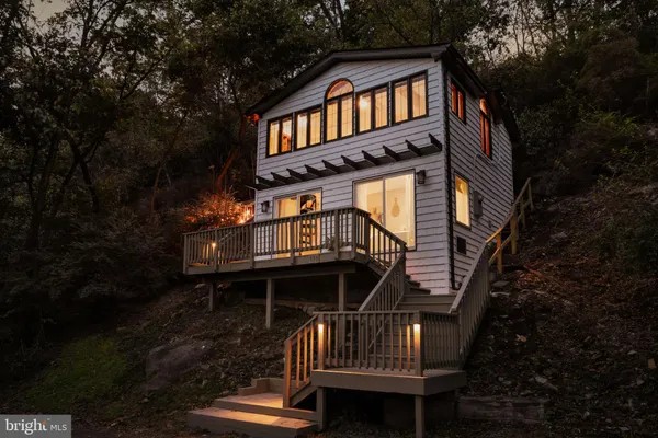 a front view of a house with yard and deck
