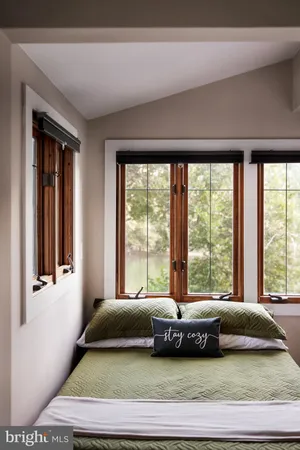 a bedroom with a bed and a large window