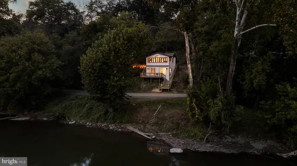 a view of a house with a yard next to a lake