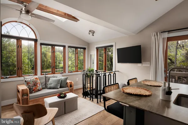 a living room with furniture a flat screen tv and a large window