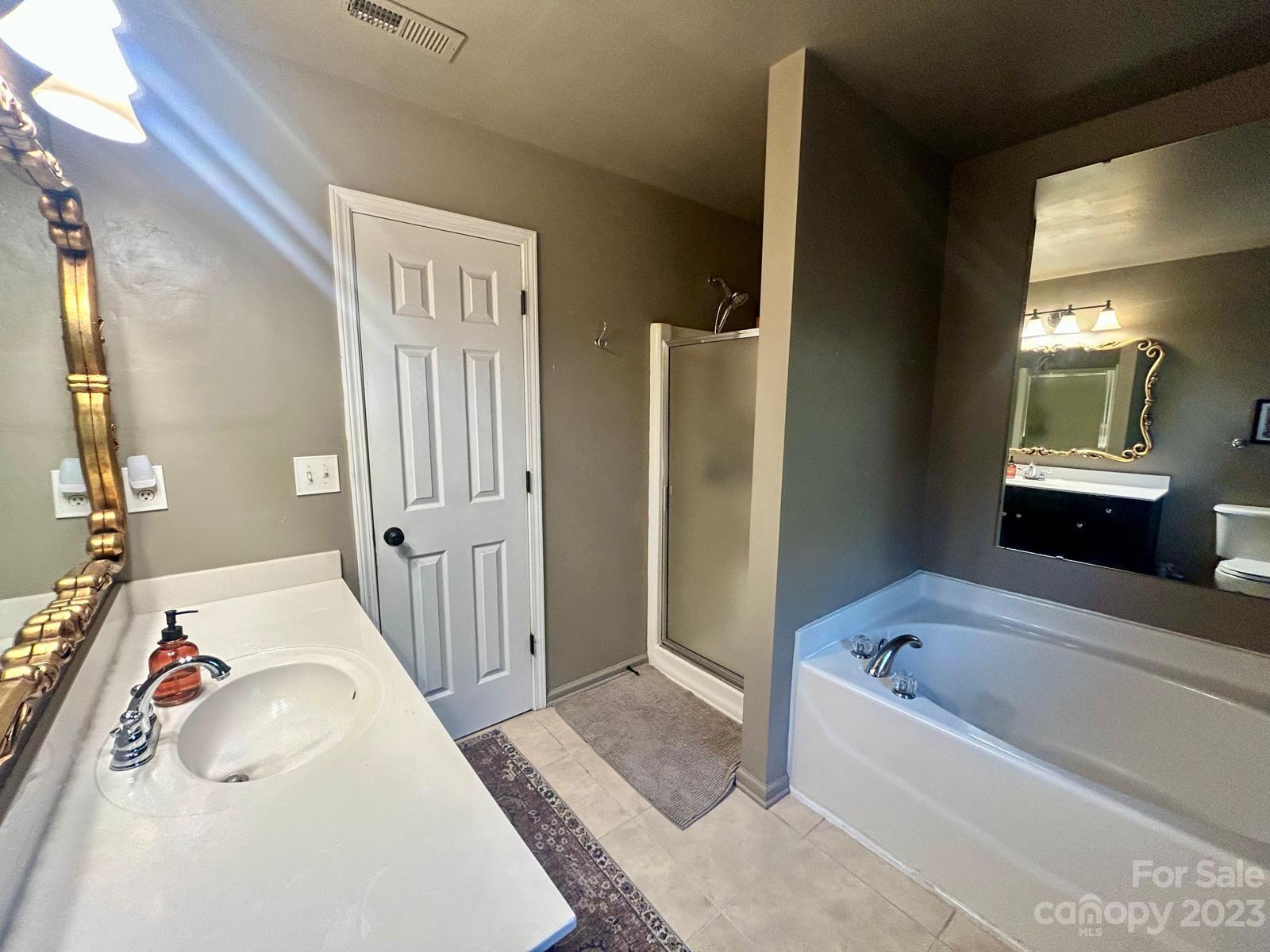 9724 Steele Meadow Road Charlotte, NC 28273 - Photo 16 of 21 a bathroom with a bathtub and a shower