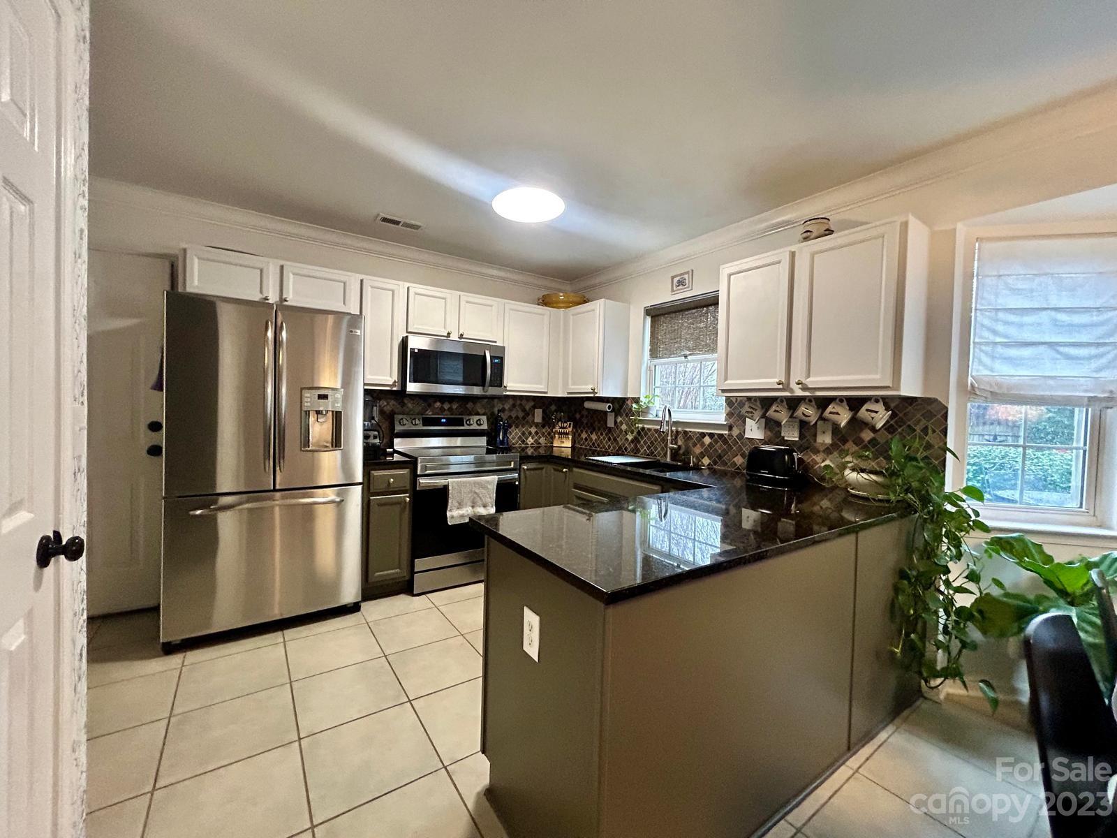 9724 Steele Meadow Road Charlotte, NC 28273 - Photo 8 of 21 a kitchen with kitchen island a counter top space a refrigerator cabinets and a sink