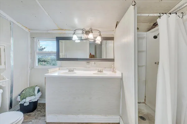 a bathroom with a granite countertop sink a toilet and shower