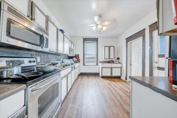 a kitchen with stainless steel appliances a sink stove and cabinets