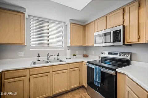 a kitchen with cabinets appliances a sink and a window