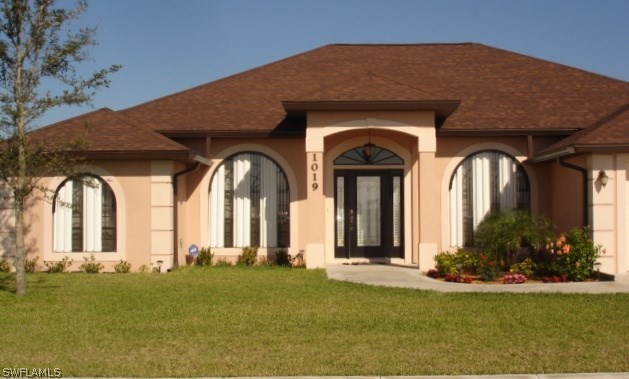 1019 Caribbean Avenue Clewiston, FL 33440 - Photo 1 of 16 a front view of a house with a garden