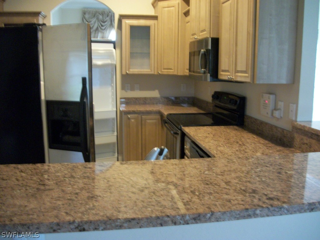 1019 Caribbean Avenue Clewiston, FL 33440 - Photo 13 of 16 a kitchen with a stove and a refrigerator