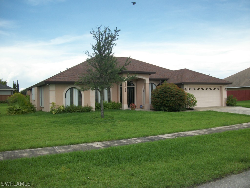 1019 Caribbean Avenue Clewiston, FL 33440 - Photo 2 of 16 a front view of a house with a garden