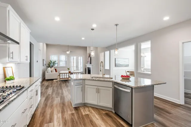 a open kitchen with stainless steel appliances granite countertop a stove and white cabinets