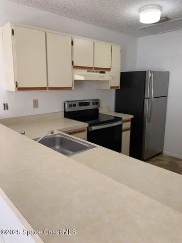 a kitchen with a refrigerator and a sink