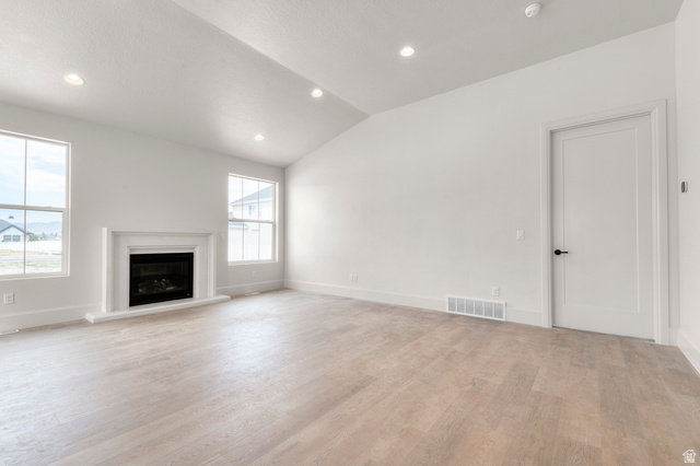 11718 South Halls Crk Road Draper, UT 84020 - Photo 13 of 28 Spacious living area featuring light wood-finish flooring, a white mantel fireplace, and two large windows