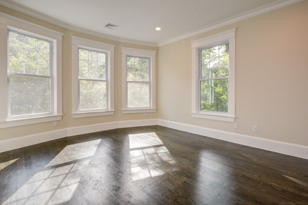 234 Langley Road Newton, MA 02459 - Photo 17 of 25 a view of an empty room with wooden floor and a window