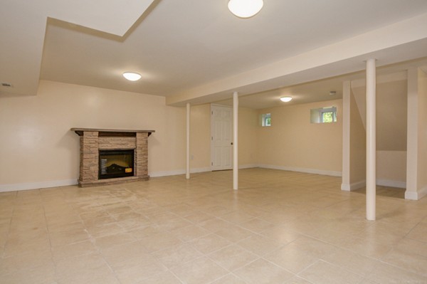 234 Langley Road Newton, MA 02459 - Photo 24 of 25 an empty room with fireplace and fan