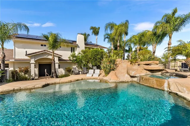a view of a house with a yard and potted plants