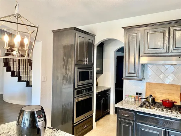 a kitchen with stainless steel appliances granite countertop a refrigerator and a stove top oven